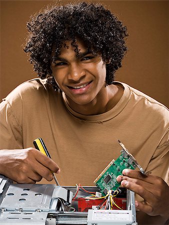 simsearch:640-02776875,k - young man in a brown shirt fixing a computer. Stock Photo - Premium Royalty-Free, Code: 640-02776888