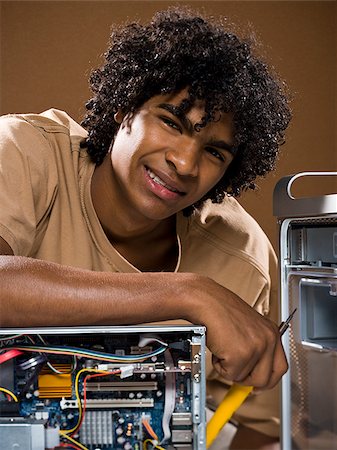 simsearch:640-02776875,k - young man in a brown shirt fixing a computer. Stock Photo - Premium Royalty-Free, Code: 640-02776889