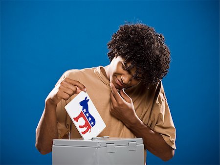 simsearch:640-02776875,k - young man in a brown shirt casting a ballot. Stock Photo - Premium Royalty-Free, Code: 640-02776907