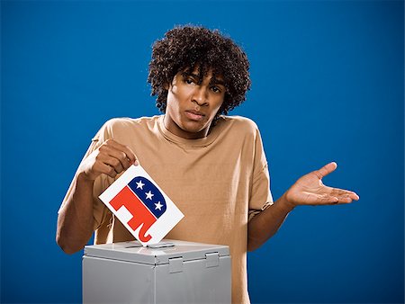 simsearch:640-02776875,k - young man in a brown shirt casting a ballot. Stock Photo - Premium Royalty-Free, Code: 640-02776909