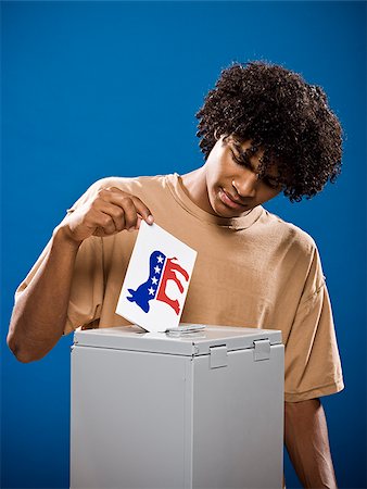 simsearch:640-02776875,k - young man in a brown shirt casting a ballot. Stock Photo - Premium Royalty-Free, Code: 640-02776911