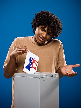 simsearch:640-02776875,k - young man in a brown shirt casting a ballot. Stock Photo - Premium Royalty-Free, Code: 640-02776913