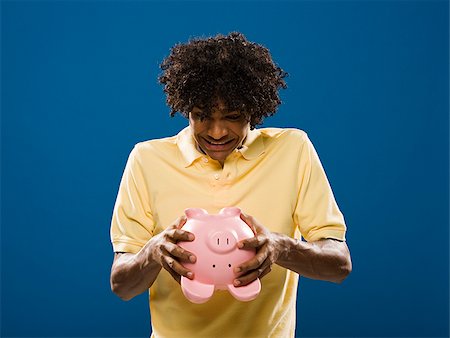 simsearch:640-02776875,k - young man trying to get money out of a piggy bank. Stock Photo - Premium Royalty-Free, Code: 640-02776925