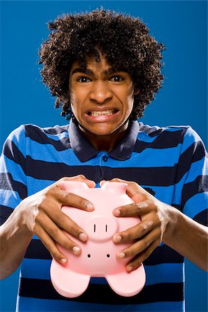 simsearch:640-02776875,k - young man trying to get money out of a piggy bank. Stock Photo - Premium Royalty-Free, Code: 640-02776926