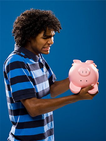 simsearch:640-02776875,k - young man trying to get money out of a piggy bank. Stock Photo - Premium Royalty-Free, Code: 640-02776927