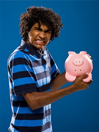 simsearch:640-02776875,k - young man trying to get money out of a piggy bank. Stock Photo - Premium Royalty-Free, Code: 640-02776928