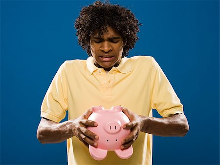 simsearch:640-02776875,k - young man trying to get money out of a piggy bank. Stock Photo - Premium Royalty-Free, Code: 640-02776923