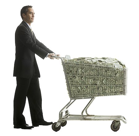 businessperson with a shopping cart full of money Stock Photo - Premium Royalty-Free, Code: 640-02778436