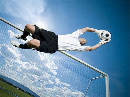 Soccer goalkeeper making diving save Stock Photo - Premium Royalty-Free, Code: 640-02770248