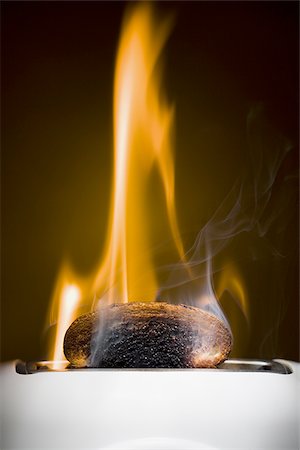 Burning toast slices in toaster Stock Photo - Premium Royalty-Free, Code: 640-02770528