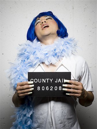 Mug shot of man in drag with blue wig and feather boa Foto de stock - Sin royalties Premium, Código: 640-02770808
