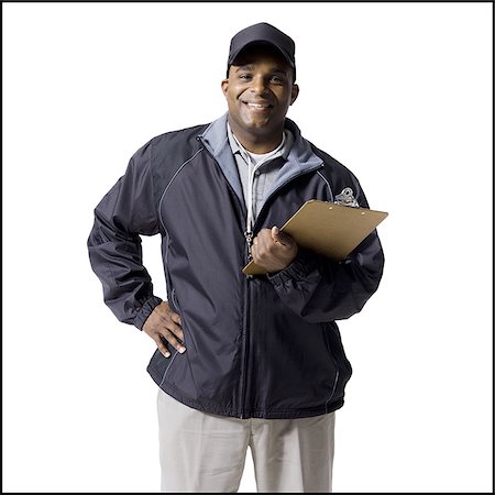 Coach with clipboard and headset smiling Stock Photo - Premium Royalty-Free, Code: 640-02771150