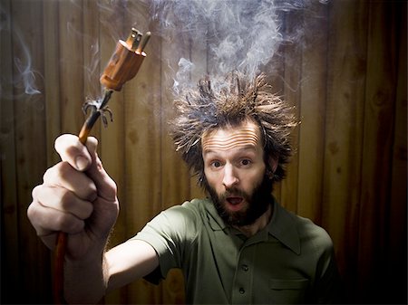 electricity plug hazards - Man after electric shock with electric plug and smoke Stock Photo - Premium Royalty-Free, Code: 640-02771287