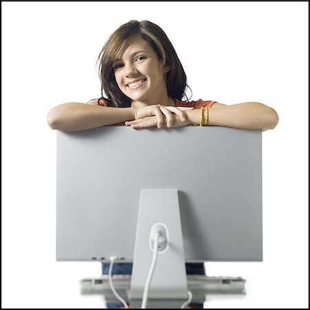 simsearch:640-02773530,k - Girl leaning on computer monitor smiling Stock Photo - Premium Royalty-Free, Code: 640-02771314