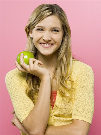 Woman smiling with green apple Stock Photo - Premium Royalty-Free, Code: 640-02771439