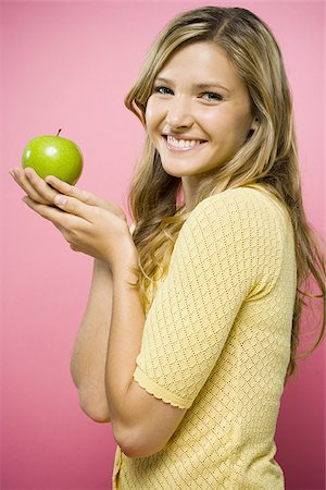 Woman smiling with green apple Stock Photo - Premium Royalty-Free, Code: 640-02771444