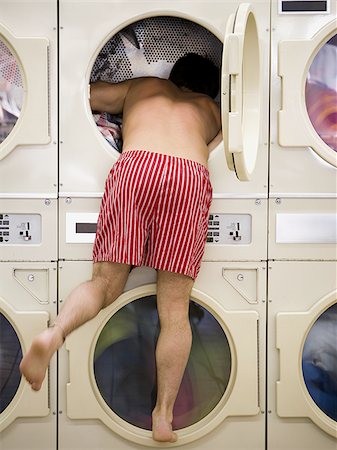 Man in boxers looking in dryer at Laundromat Stock Photo - Premium Royalty-Free, Code: 640-02771648
