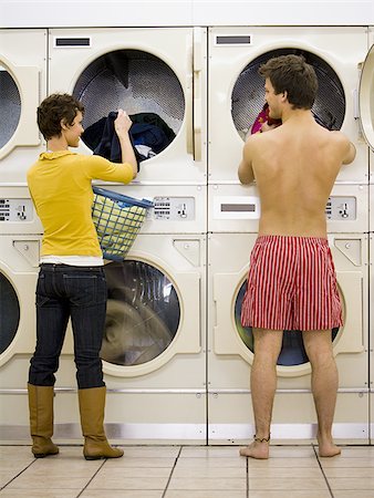 Woman and man in boxers removing clothing from dryers at Laundromat Foto de stock - Sin royalties Premium, Código: 640-02771652