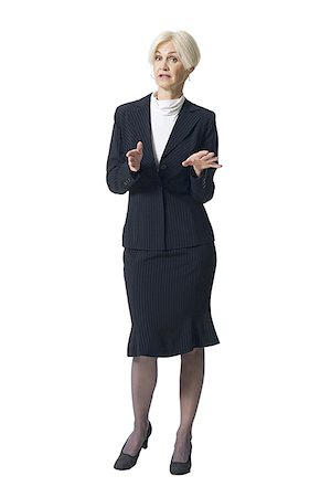Mature businesswoman standing and gesturing with hands Stock Photo - Premium Royalty-Free, Code: 640-02771839
