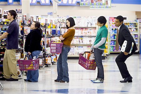 People waiting in line with shopping baskets at grocery store Stock Photo - Premium Royalty-Free, Code: 640-02772283