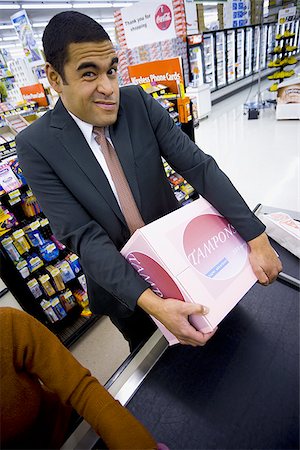 Man at grocery checkout with box of tampons and two women Stock Photo - Premium Royalty-Free, Code: 640-02772293