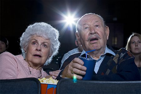 Man and woman watching film at movie theatre frightened Stock Photo - Premium Royalty-Free, Code: 640-02773361