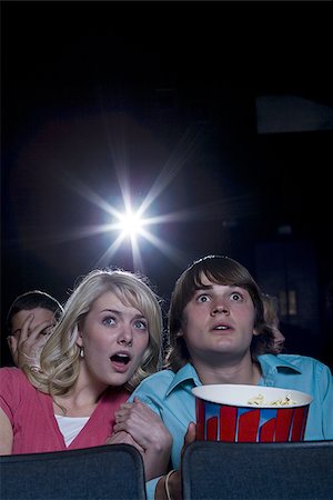 simsearch:640-02773406,k - Boy and girl with popcorn frightened at movie theater Stock Photo - Premium Royalty-Free, Code: 640-02773385