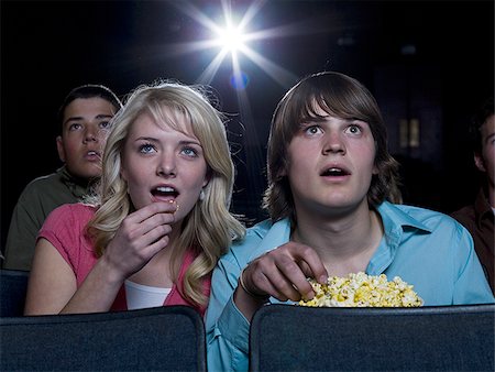 simsearch:640-02773406,k - Boy and girl with popcorn frightened at movie theater Stock Photo - Premium Royalty-Free, Code: 640-02773383