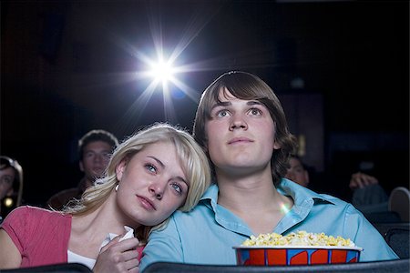 Girl crying at movie theater with boy and popcorn Stock Photo - Premium Royalty-Free, Code: 640-02773395