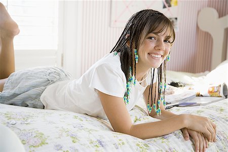 simsearch:640-02773530,k - Girl with braids lying down on bed smiling Stock Photo - Premium Royalty-Free, Code: 640-02773547