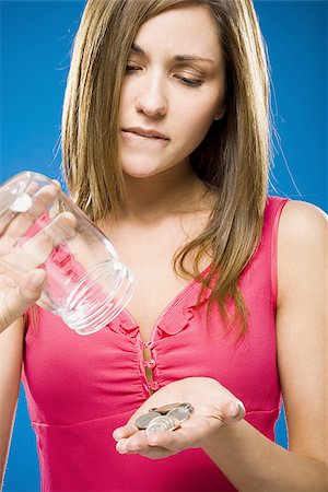 Woman emptying coins from jar into hand Stock Photo - Premium Royalty-Free, Code: 640-02773950