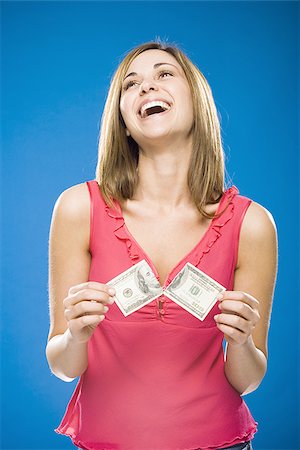 Woman tearing American hundred dollar bill smiling Stock Photo - Premium Royalty-Free, Code: 640-02773981