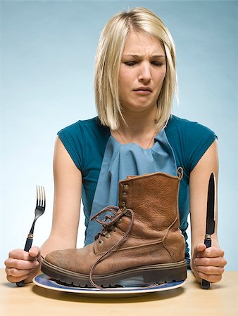 disgust - woman eating a boot Stock Photo - Premium Royalty-Free, Code: 640-02948158