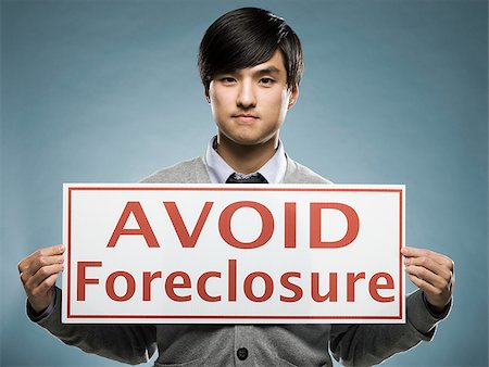 man holding an "avoid foreclosure" sign Stock Photo - Premium Royalty-Free, Code: 640-02948685