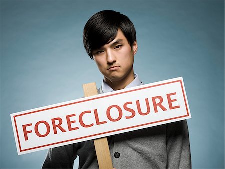 man holding a foreclosure sign Stock Photo - Premium Royalty-Free, Code: 640-02948689
