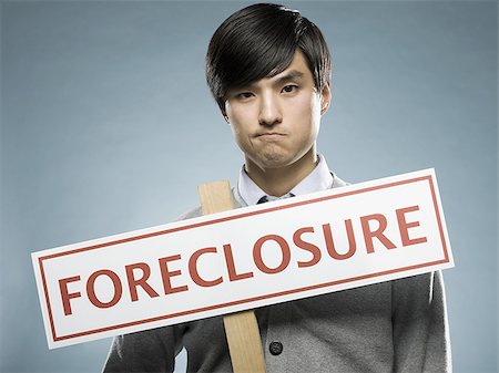 man holding a foreclosure sign Stock Photo - Premium Royalty-Free, Code: 640-02948690