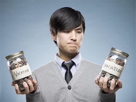 man holding two jars of coins Stock Photo - Premium Royalty-Free, Code: 640-02948710