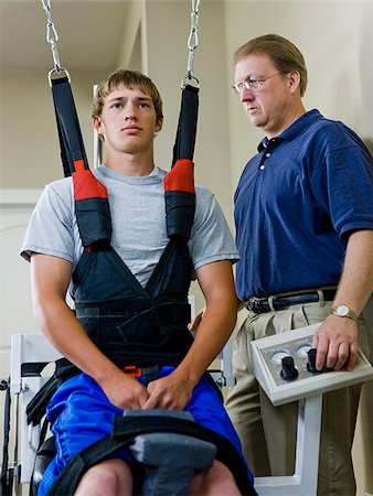 physiotherapist - young man in a suspension harness Foto de stock - Sin royalties Premium, Código: 640-02949654