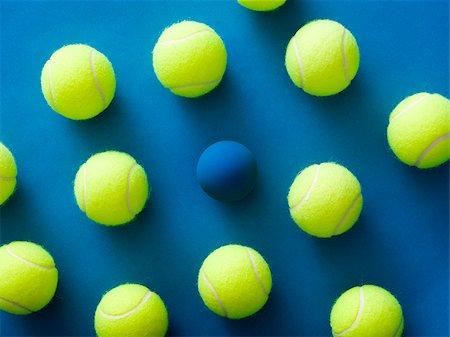 stand out - tennis balls and a racquetball against a blue background Stock Photo - Premium Royalty-Free, Code: 640-02950256