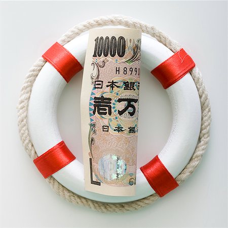 devalue - japanese yen in a life preserver Stock Photo - Premium Royalty-Free, Code: 640-02950636