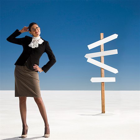 road signs in us - businesswoman looking at a road sign Stock Photo - Premium Royalty-Free, Code: 640-02951597