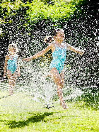 children playing in a sprinkler Stock Photo - Premium Royalty-Free, Code: 640-02951662