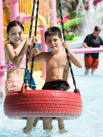 children on a tire swing at a waterpark Stock Photo - Premium Royalty-Free, Code: 640-02951743