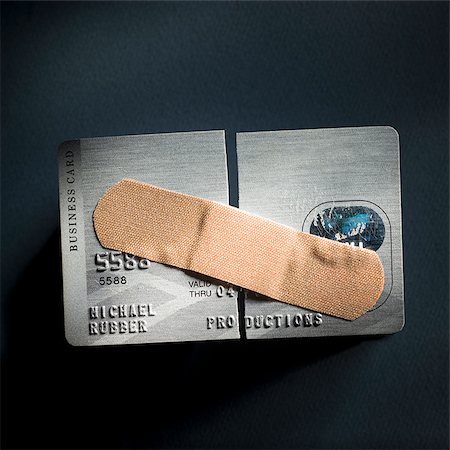 credit card cut in half with a band-aid holding it together Stock Photo - Premium Royalty-Free, Code: 640-02952138