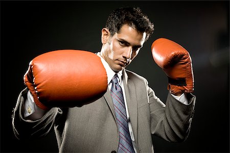 businessman wearing boxing gloves Stock Photo - Premium Royalty-Free, Code: 640-02952267