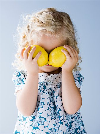 single lemon - little girl holding lemons in front of her eyes Stock Photo - Premium Royalty-Free, Code: 640-02952419