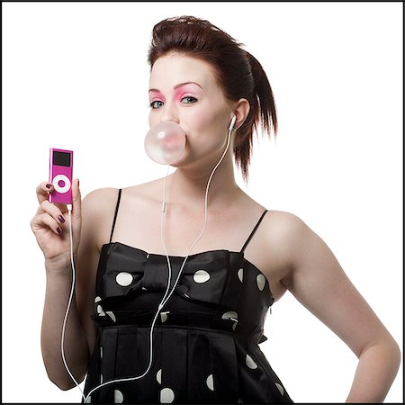 woman listening to digital music on her ipod blowing a bubble Stock Photo - Premium Royalty-Free, Code: 640-02952437