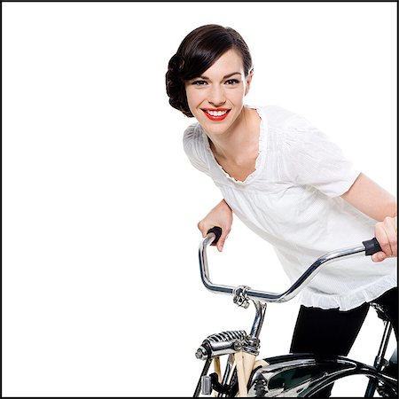 woman with her hair up in a classic hollywood hairstyle reminiscent of the 1940s riding a bike Stock Photo - Premium Royalty-Free, Code: 640-02952467