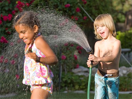 little boy spraying a little girl with the hose Foto de stock - Sin royalties Premium, Código: 640-02952996