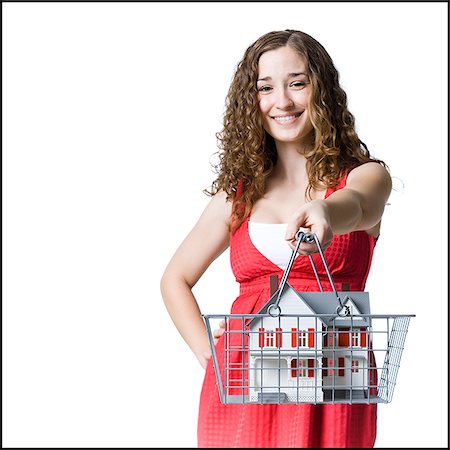 person holding a miniature house in a shopping basket Stock Photo - Premium Royalty-Free, Code: 640-02953436